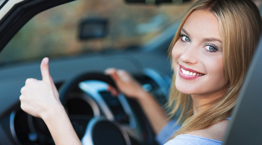 Person in driver's seat smiling and gesturing