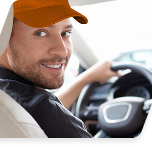 Smiling man in orange cap driving car