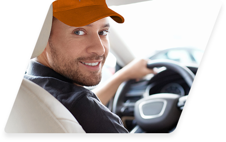 Smiling man in orange cap driving car